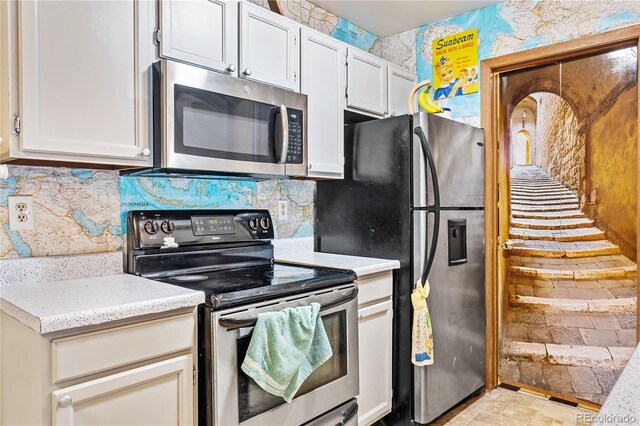 kitchen with appliances with stainless steel finishes, decorative backsplash, and white cabinets