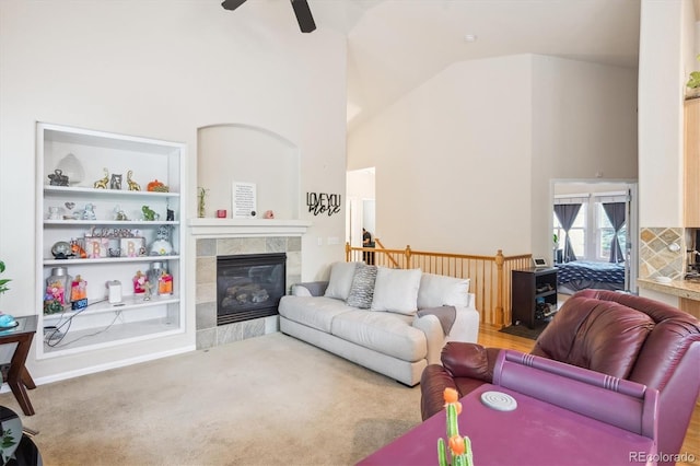 21063 E Greenwood Pl, Aurora, CO 80013 - carpeted living area featuring high vaulted ceiling, a ceiling fan, a tiled fireplace, and built in features