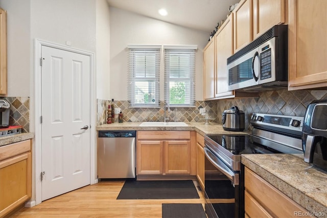 21063 E Greenwood Pl, Aurora, CO 80013 - kitchen featuring stainless steel appliances, a sink, vaulted ceiling, tasteful backsplash, and light wood-type flooring