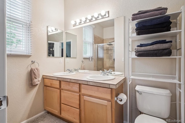 21063 E Greenwood Pl, Aurora, CO 80013 - full bath featuring double vanity, a shower stall, a textured wall, toilet, and baseboards