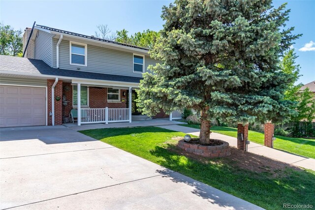 6150 Reed St, Arvada, CO 80003 - view of front of property with a porch, an attached garage, a front lawn, driveway, and brick siding