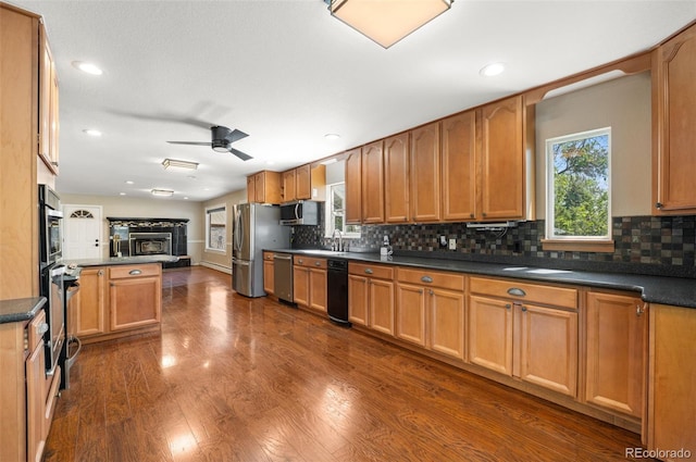 6150 Reed St, Arvada, CO 80003 - kitchen with appliances with stainless steel finishes, open floor plan, ceiling fan, dark wood-style flooring, and backsplash