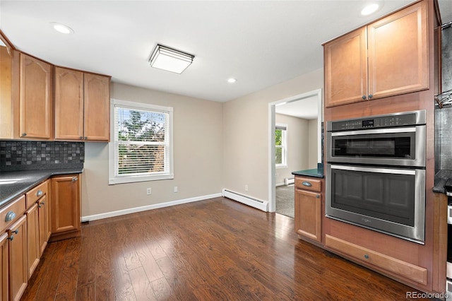 6150 Reed St, Arvada, CO 80003 - kitchen featuring a baseboard heating unit, stainless steel double oven, healthy amount of natural light, dark countertops, and recessed lighting