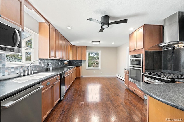 6150 Reed St, Arvada, CO 80003 - kitchen with stainless steel appliances, wall chimney exhaust hood, a ceiling fan, baseboards, and dark countertops
