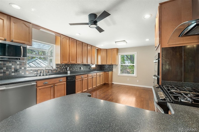 6150 Reed St, Arvada, CO 80003 - kitchen with stainless steel appliances, a sink, a ceiling fan, dark wood-style flooring, and backsplash
