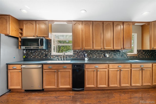 6150 Reed St, Arvada, CO 80003 - kitchen featuring appliances with stainless steel finishes, a sink, dark countertops, tasteful backsplash, and recessed lighting