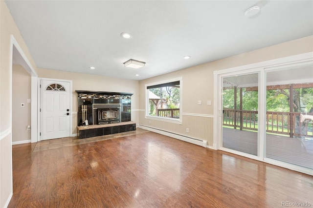 6150 Reed St, Arvada, CO 80003 - unfurnished living room with a baseboard heating unit, wood finished floors, recessed lighting, a tiled fireplace, and baseboards