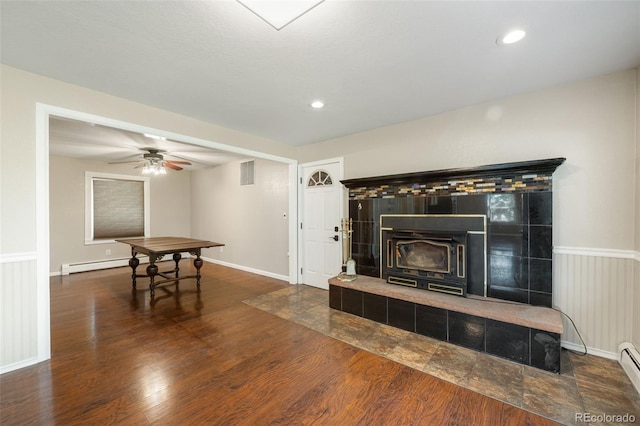 6150 Reed St, Arvada, CO 80003 - living room with a wood stove, a baseboard heating unit, wood finished floors, ceiling fan, and recessed lighting