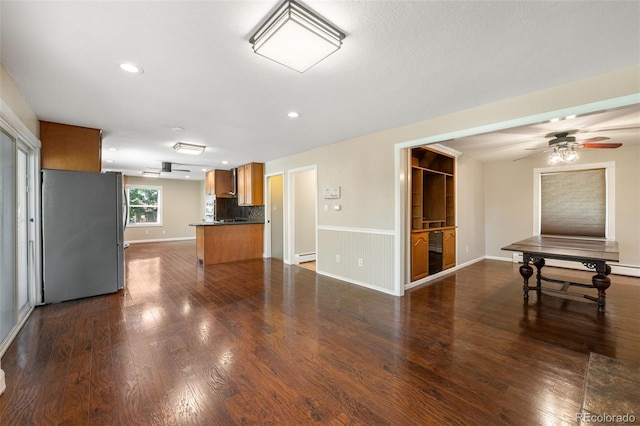 6150 Reed St, Arvada, CO 80003 - unfurnished living room featuring dark wood finished floors, ceiling fan, recessed lighting, and a wainscoted wall