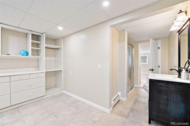 6150 Reed St, Arvada, CO 80003 - walk in closet featuring baseboard heating, a sink, and a paneled ceiling
