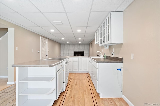 6150 Reed St, Arvada, CO 80003 - kitchen featuring open shelves, white electric stove, light wood-type flooring, white cabinets, and glass insert cabinets