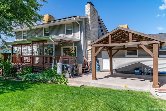 6150 Reed St, Arvada, CO 80003 - back of property featuring a chimney, a lawn, ceiling fan, a patio area, and a deck