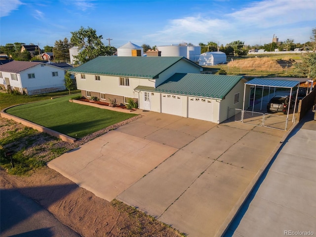 view of front facade featuring metal roof, an attached garage, concrete driveway, a carport, and a front lawn