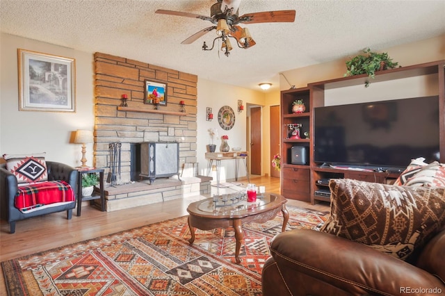 living room featuring a textured ceiling, wood finished floors, and a ceiling fan