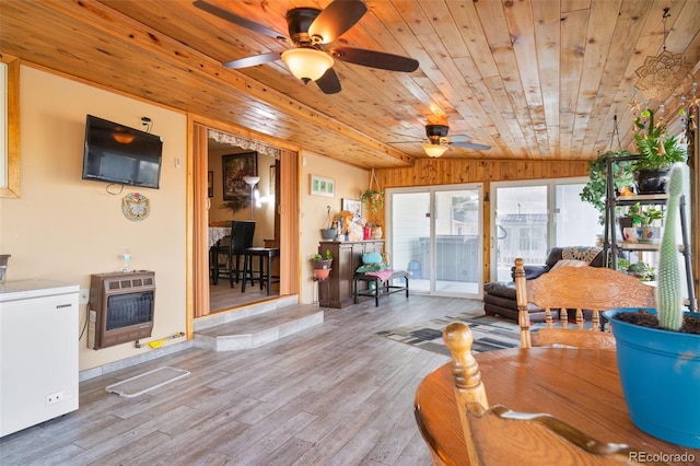 interior space featuring heating unit, a sunroom, vaulted ceiling, wood finished floors, and wooden ceiling