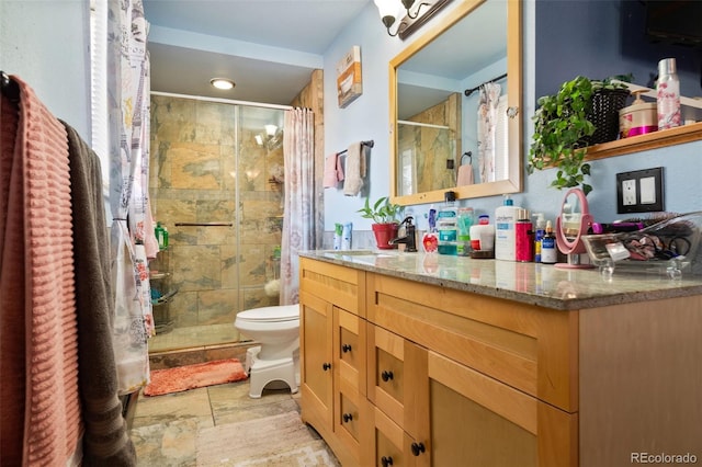 full bathroom with a stall shower, stone tile flooring, vanity, and toilet