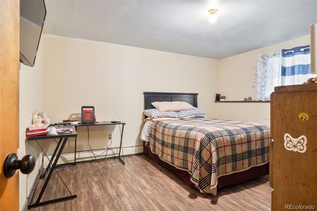 bedroom with baseboards and wood finished floors