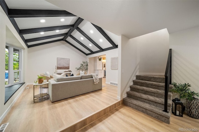 living room featuring lofted ceiling with beams and light wood-type flooring