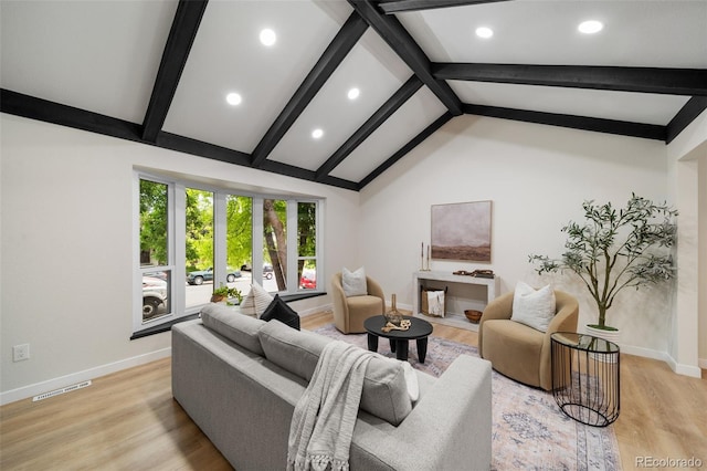 living room featuring french doors, light wood-type flooring, and vaulted ceiling with beams