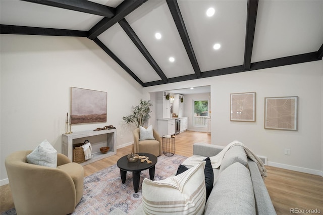 living room featuring beam ceiling, high vaulted ceiling, and light wood-type flooring