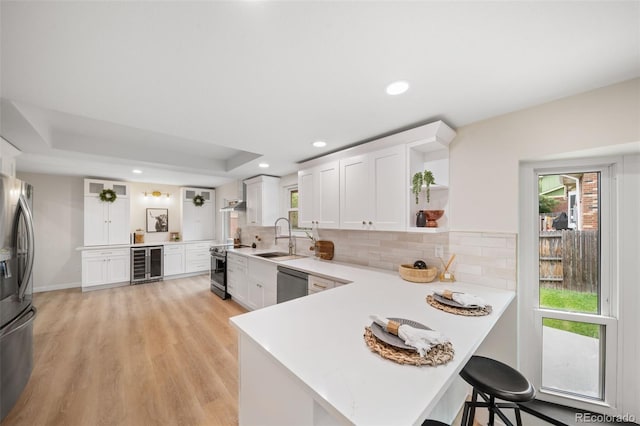 kitchen with wine cooler, kitchen peninsula, and white cabinets