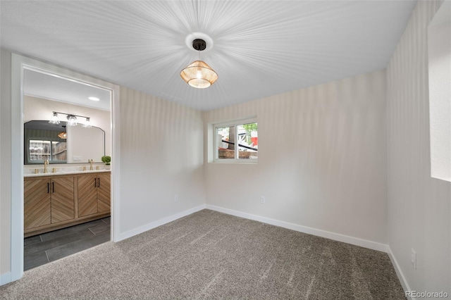 unfurnished room featuring sink and carpet