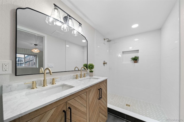 bathroom with vanity and a tile shower