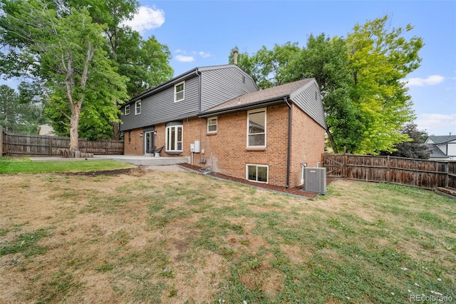 back of property with cooling unit, a yard, and a patio