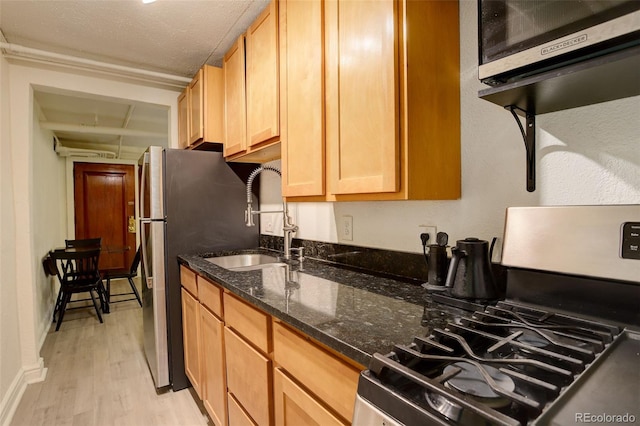 1060 N Washington St Unit 1A, Denver, CO 80203 - kitchen featuring stainless steel appliances, light wood-style flooring, and dark stone countertops