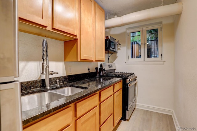 1060 N Washington St Unit 1A, Denver, CO 80203 - kitchen featuring appliances with stainless steel finishes, light wood finished floors, and dark stone countertops