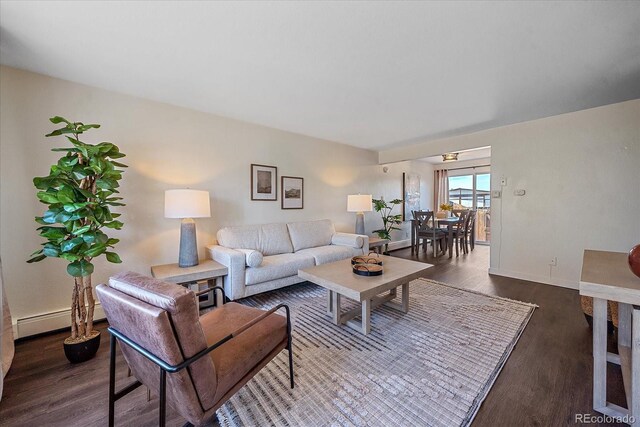 living area with a baseboard radiator, dark wood-style flooring, and baseboards