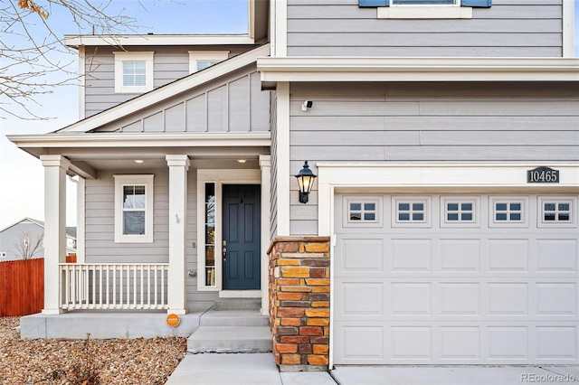 entrance to property with covered porch and a garage