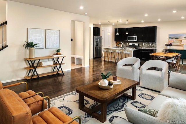 living room with dark hardwood / wood-style flooring and sink