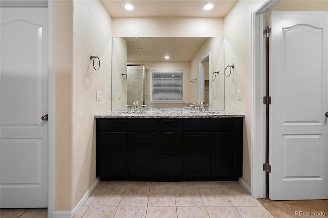 bathroom with tile patterned flooring, walk in shower, and vanity