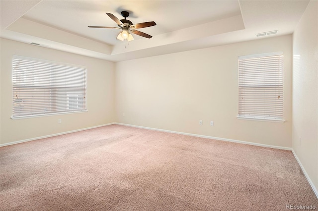 unfurnished room with carpet floors, ceiling fan, and a tray ceiling