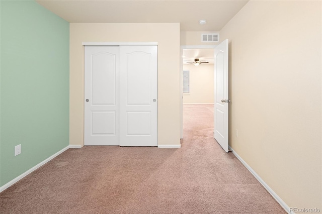 unfurnished bedroom featuring light colored carpet and a closet