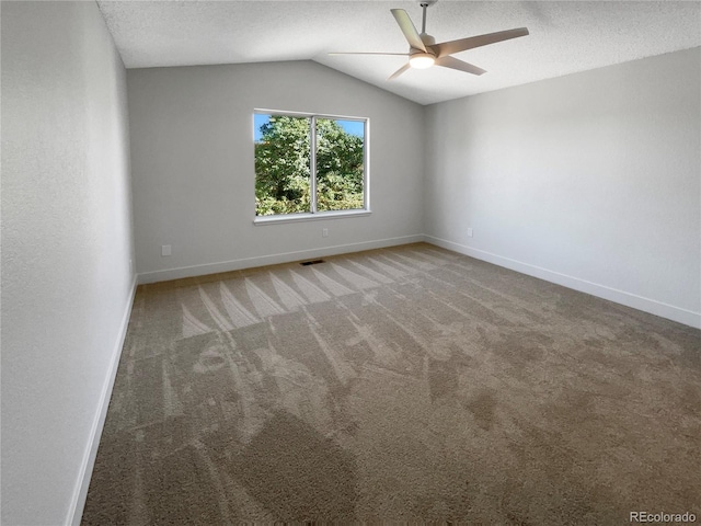 carpeted empty room with a textured ceiling, vaulted ceiling, and ceiling fan