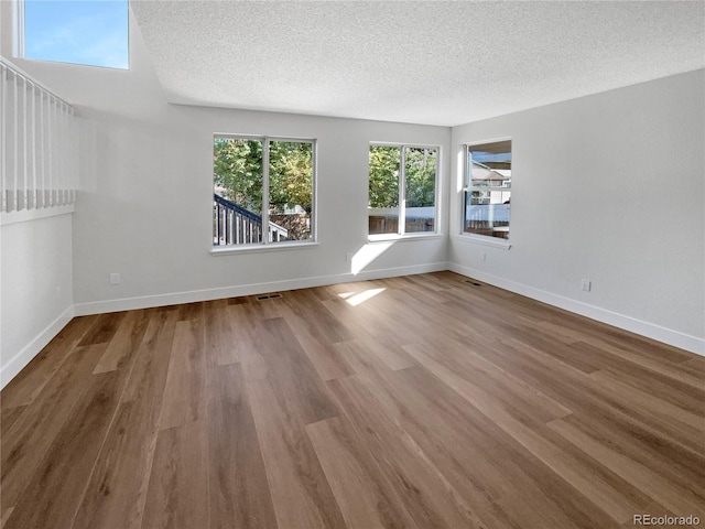 empty room with a textured ceiling and hardwood / wood-style floors