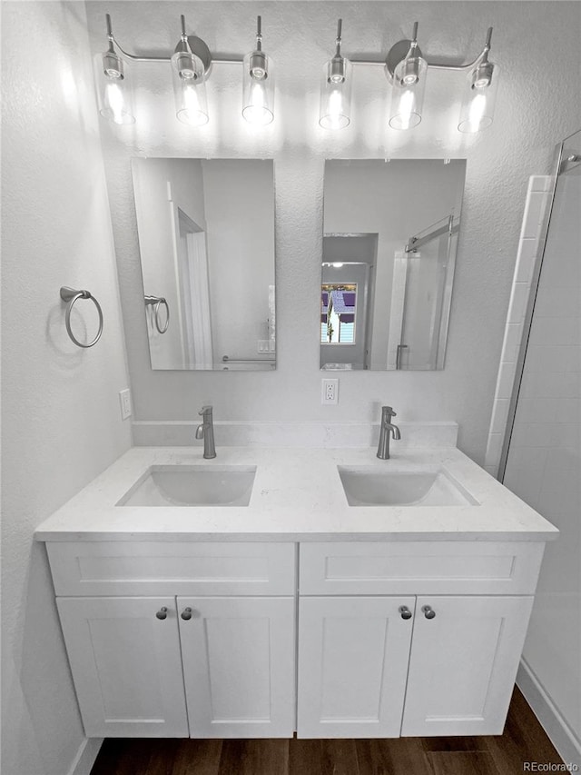 bathroom featuring walk in shower, vanity, and hardwood / wood-style floors