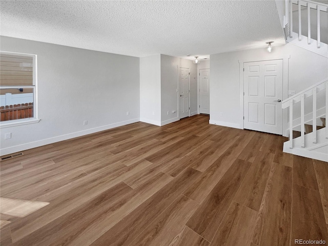 spare room featuring a textured ceiling and hardwood / wood-style flooring