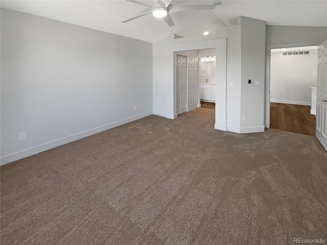 unfurnished bedroom with dark carpet, lofted ceiling, and ceiling fan