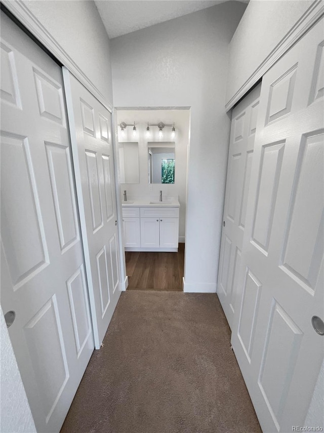 hall featuring dark carpet and sink