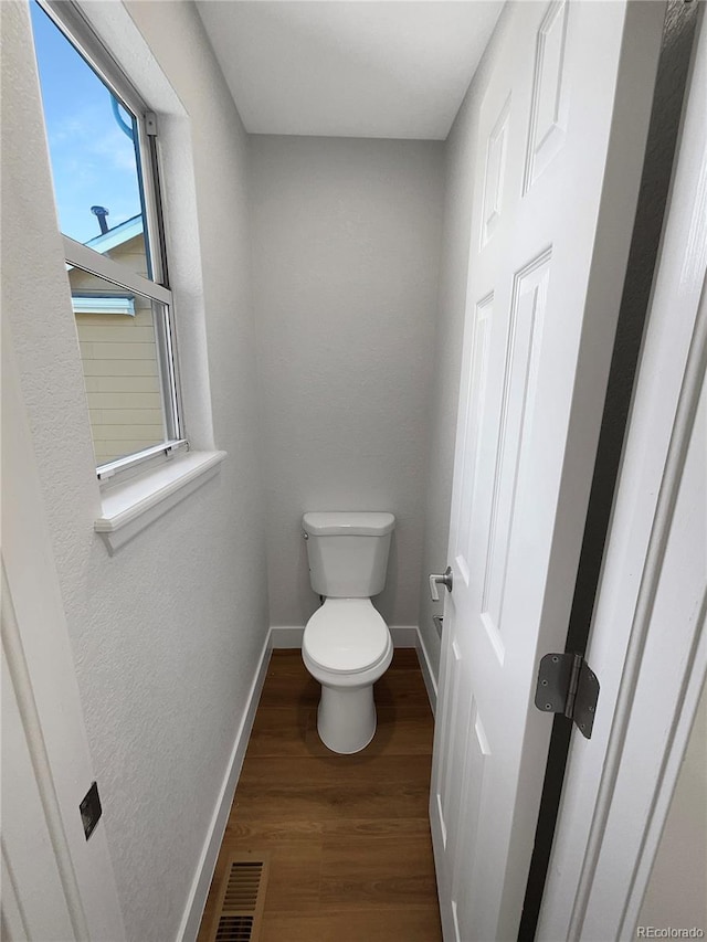 bathroom featuring hardwood / wood-style floors and toilet