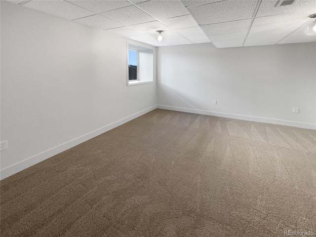 carpeted spare room featuring a drop ceiling