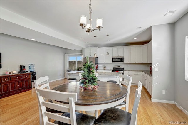 dining room featuring a notable chandelier and light hardwood / wood-style floors