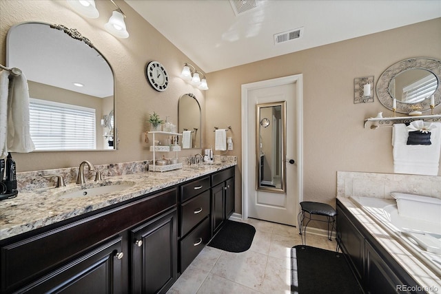 full bathroom with tile patterned floors, double vanity, visible vents, and a sink