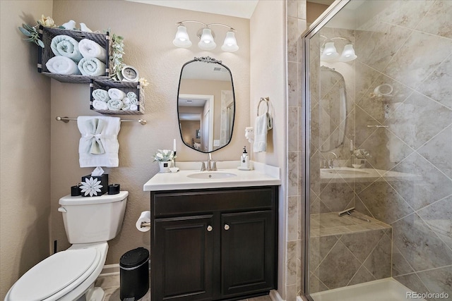 full bathroom with vanity, a shower stall, and toilet