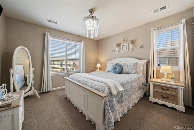 carpeted bedroom featuring visible vents, baseboards, and a notable chandelier