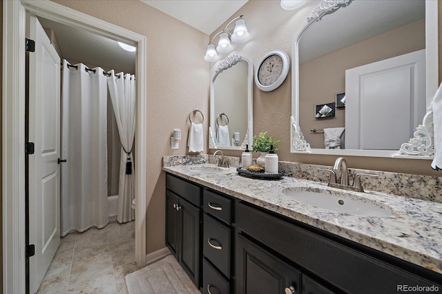 bathroom featuring double vanity, a shower with curtain, and a sink