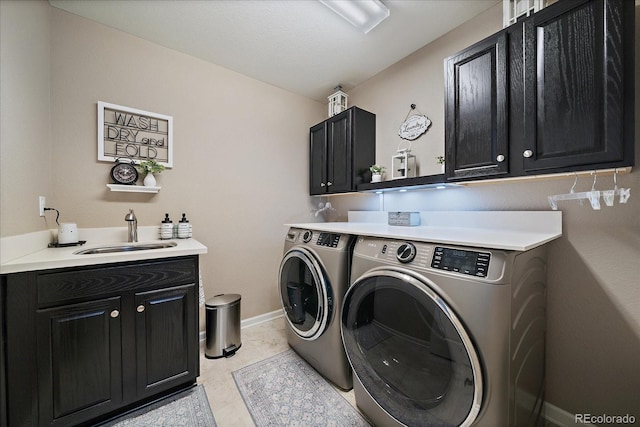 laundry area with a sink, baseboards, cabinet space, and separate washer and dryer